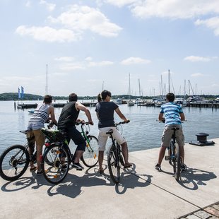Schleiufer am Schleswiger Stadthafen mit Fahrrad-Touristen/innen.